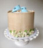 Baby shower cake with blue baby boots on top