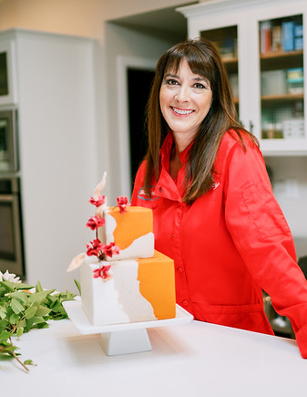 Tracy Van Orden in red chef's jacket with cake